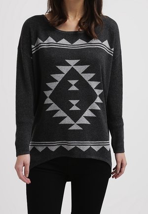 Pull gris avec un motif géométrique blanc, doté d'une coupe décontractée, d'un large décolleté et de manches longues. Fabriqué à partir d'un tissu doux et texturé.