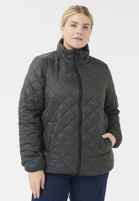 Quilted black puffer jacket with high collar, zip closure, and side pockets. Made from shiny material, featuring a diamond pattern.