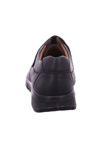 Black leather shoe with a rounded back, textured surface, and rubber sole. Features subtle stitching and a cushioned inner lining.