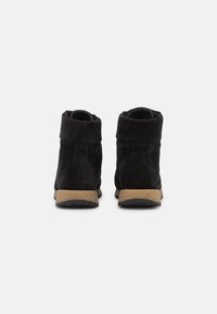 Bottines en daim noir à surface texturée, dotées d'une semelle en caoutchouc beige et d'un détail au niveau du revers arrière pour plus de confort et de soutien.
