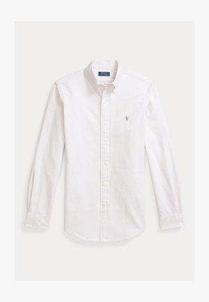 Valge triiksärk, millel on hele sinised ja beežid vertikaalsed triibud. Omadusteks on terav krae, pikad varrukad ja väike tikkitud logo rinnal.