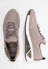 Szare buty sportowe wykonane z siateczki i zamszu. Posiadają fakturowane sznurowadła, minimalistyczne ozdoby, białą środkową podeszwę oraz wzorzystą gumową podeszwę zewnętrzną.