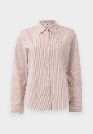 Sarkana un balta svītrota krekliņa ar garām piedurknēm, pogājamā josta un apkakles izgriezums, kā arī neliels logo kreisajā krūtī; mīksta, teksturēta auduma.