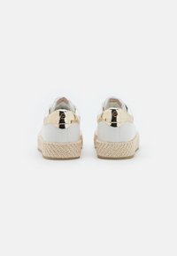 Bílé sneakersy z umělé kůže se zlatým akcentem na patě a tkaným pleteným juty středním sem. Kulatá špička a polstrovaný interiér.