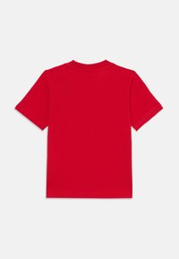 Rød bomulls t-skjorte med korte ermer, rund hals, og ensfarget design. Glatt tekstur uten synlige mønstre eller detaljer.