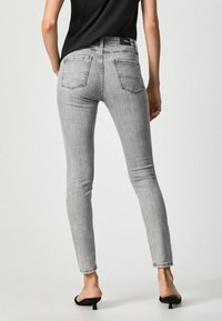 Grå smala jeans med hög midja, med klassisk femficksdesign, subtil blekning och en mjuk denimtextur.