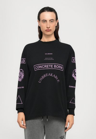 Maglietta nera a maniche lunghe in cotone, con grafiche viola, testo e un disegno di leone sulle maniche, con vestibilità rilassata e scollo tondo.