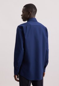 Marineblauwe longsleeve shirt, geweven stof, puntige kraag, met knoopmanchetten, getailleerde pasvorm, gladde afwerking, ontworpen voor een ontspannen silhouet.