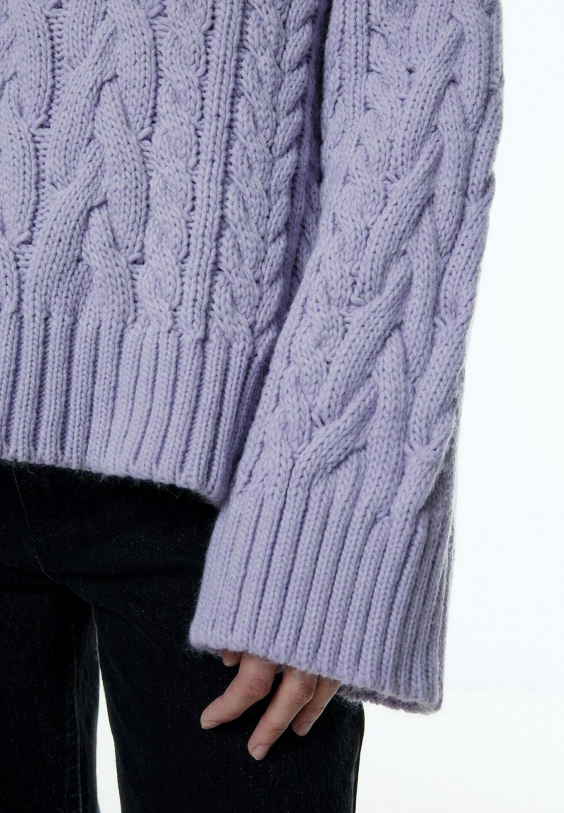 Helllila Strickpullover mit Kabelmuster, sowie jeweils gerippten Manschetten und Saum. Verfügt über eine komplexe geflochtene Textur und ein übergroßes, gemütliches Design.