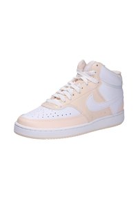 Des baskets montantes en cuir souple et matériau synthétique. Principalement crème avec des accents blancs, présentant une pointe perforée et des lacets.