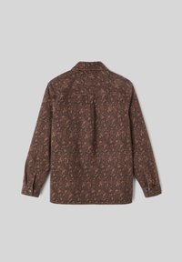 Chemise marron à motifs avec des manches longues, arborant un design de feuilles dans des tons plus foncés, avec des poignets boutonnés et un col, fabriquée à partir d'un tissu texturé.