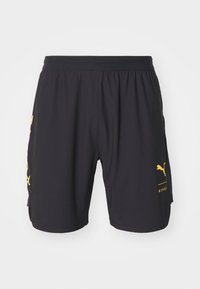 Pantalones cortos deportivos negros hechos de material ligero, con un logo amarillo y texto en la pierna izquierda, y una cintura elástica para mayor comodidad.