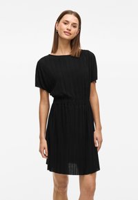 Vestido preto plissado com mangas curtas e decote redondo, apresentando uma cintura elástica e uma barra rodada. Textura suave.