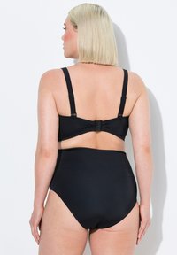 Černý bikiny set obsahující podprsenku s vycpávkami a nastavitelnými ramínky a spodní část se zvýšeným pasem. Hladká tkanina s minimálním designem a decentním kováním.