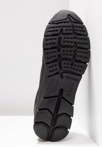 Soletta nera di sneaker in gomma texturizzata, con profonde scanalature per la trazione e piccole perforazioni per la traspirabilità. Brand Geox visibile.