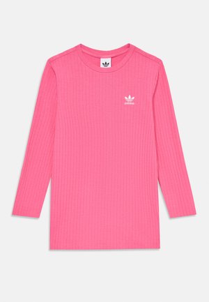 Różowa, długosławkowa koszula z żeberkami, uszyta z miękkiego materiału, z białym logo adidas na klatce piersiowej oraz klasycznym okrągłym dekoltem.