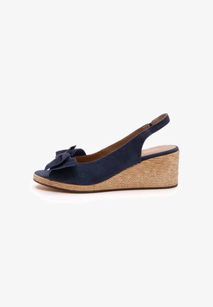 Marineblå ruskind kilehæl sandal med åben tå, sløjfedetalje foran og en tekstureret jute kilehæl. Slingback-rem for sikker pasform.