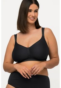 Sujetador inalámbrico negro con tejido suave, tirantes anchos y un diseño de copa sin costuras. Presenta una costura mínima y una banda inferior elástica para mayor comodidad.