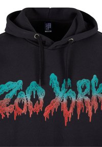 Black hoodie featuring "Zoo York" graphic in turquoise and red dripping letters. Material appears soft with a standard fit and adjustable drawstring.