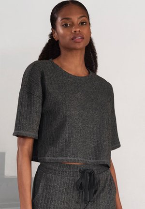 Grijze cropped top met korte mouwen, gestructureerd ribbelmateriaal, ronde halslijn en een subtiele glans. Gekleed met bijpassende broek met tailleband.