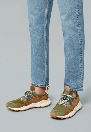 Sneaker verdi e marroni con un mix di materiali scamosciati e a rete; presentano un collare imbottito, accenti contrastanti arancioni e blu, e una suola testurizzata.