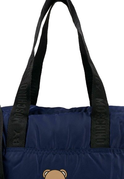 Granatowa torba tote z podszewką, z czarnymi paskami, z logo "Moschino"; zawiera grafikę misia na przedniej części.