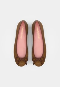 Ballerines en suède marron avec un bout arrondi, un nœud tressé à l'avant et une doublure intérieure rose. Texture lisse et design simple.