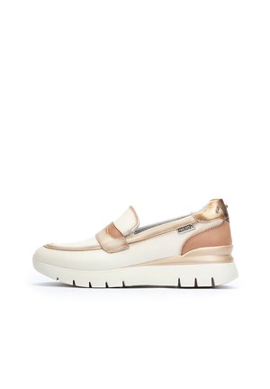 Zapatilla tipo slip-on con parte superior de cuero blanco y acentos en beige y dorado metálico, suela acolchada y diseño de punta redondeada.