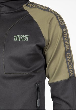 Musta ja oliivinvihreä pitkähihainen pullover, jossa on vetoketjullinen tasku. Vasemmassa olkapäässä ja hihassa on "WRONG FRIENDS" -brändäys.