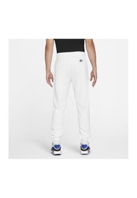 Vita sweatpants med elastiskt midjeband, med en liten färgglad logotyp på baksidan. Tyget verkar mjukt och tjockt, vilket gör dem lämpliga för avslappnad användning.