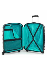 Valigia rigida con un vivace interno turchese, accessori neri, molteplici tasche e cinghie incrociate per un confezionamento sicuro.