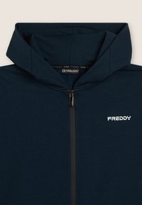 Felpa con zip di colore blu navy, con cappuccio, zip metallica e logo bianco "FREDDY" sul lato sinistro del petto.