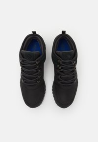 Zapatos de senderismo negros con parte superior de tela texturizada, cuello acolchado y punta reforzada. Presentan un diseño de cordones y suela de goma para tracción.