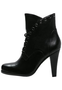 Botín negro de cuero con tacón alto, cierre con cordones en la parte delantera y ojales metálicos decorativos en el borde, con una textura suave y puntera redondeada.