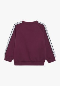 Sudadera granate con franjas laterales blancas que presenta un patrón de logotipos. Material suave, puños acanalados y cuello redondo. Vista trasera mostrada.