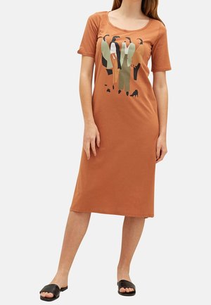 Robe t-shirt couleur rouille avec un col rond, présentant un graphique de figures dans diverses couleurs, des manches courtes et une silhouette droite.