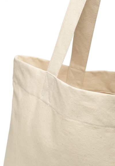 Sac en toile de coton beige clair avec deux poignées robustes, présentant une forme rectangulaire et des détails de couture minimaux.