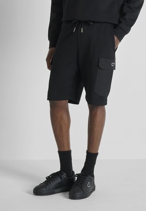 REGULAR FIT IN INTERLOCK  WITH PLATE ON CONTRAST POCKET - Pantaloni sportivi - black