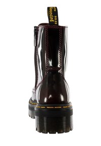 Chelsea-boots i burgunderfärgad lackläder med svarta chunkysulor. Har en sidoknäppning och en gul märkesdragflik på baksidan.