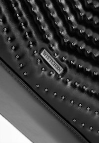 Czarna teksturowana skóra z wypukłymi kropkami, z srebrnym prostokątnym logo WITTCHEN. Gładka i błyszcząca powierzchnia z subtelnymi falistymi wzorami.