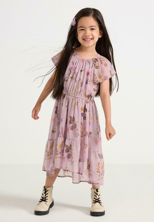 Lavendelfarvet blomsterkjole med korte flagrende ærmer, lagdelt design og elastisk talje; kombineret med beige snørelårstøvler.