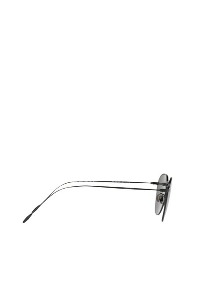 Occhiali da sole tondi con montatura in metallo nero, aste sottili e lenti scure. Include nasalini regolabili e un design elegante e minimalista.