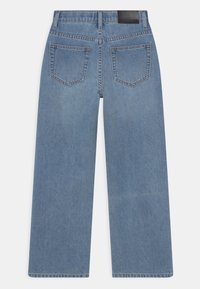 Lyseblå lige ben jeans lavet af denim, med høj talje, to baglommer og et sort lædermærke på taljebåndet.