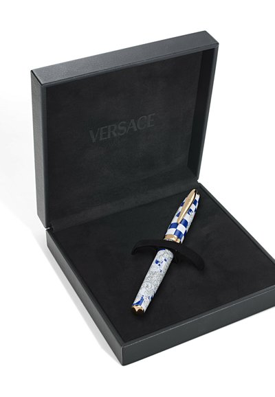 Pióro Versace w czarnej boxie. Pióro posiada niebieską kratkę na górze oraz ozdobne srebrne detale na korpusie, z złotymi akcentami. Czarny aksamitny wyściółka.
