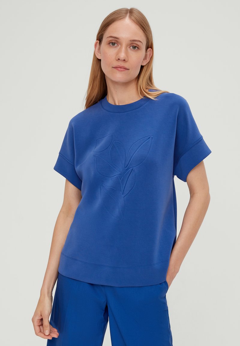 Blauwe sweatshirt met een ronde hals en korte mouwen, voorzien van een reliëfbladdesign op de voorkant. Gladde textuur en een ontspannen pasvorm.