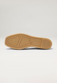 Sole di scarpa in gomma con un motivo a nido d'ape testurizzato, di colore marrone chiaro e forma arrotondata. Include un design con bordo liscio.