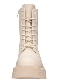 Stivaletto in pelle beige con laccio, punta rotonda e suola spessa. Presenta una cerniera laterale e dettagli di cucitura lungo i bordi.