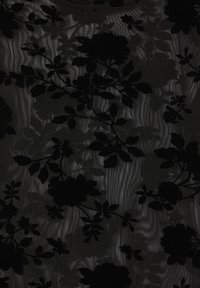 Tessuto nero trasparente con un motivo floreale in texture vellutata, caratterizzato da rose scure e foglie su uno sfondo nero leggermente lucido.