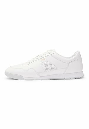 Weiße Sneaker mit einem Obermaterial aus glattem Leder, durchbrochenen Akzenten, einer gepolsterten Ferse und einer Gummisohle. Mit goldener Markenprägung an der Seite.