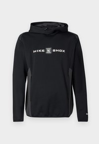 Μαύρο φούτερ Nike Shox με γκρι λογότυπο στο μπροστινό μέρος, διαθέτει κουκούλα με κορδόνι και μακριά μανίκια. Ομαλή υφή, αθλητική εφαρμογή.